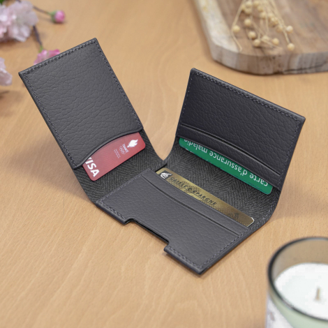 Porte-cartes gris ouvert avec plusieurs cartes.