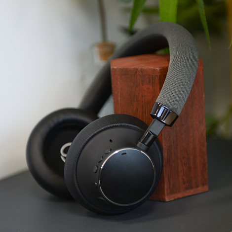 Vue rapprochée du casque posé, permettant d’observer les boutons de commande intégrés sur l’écouteur et les articulations de l’a
