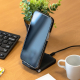 Chargeur induction branché sur bureau en bois avec smartphone posé dessus. Chargeur induction branché sur bureau en bois avec smartphone posé dessus.