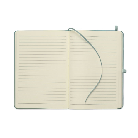 Cahier A5 ouvert présentant deux pages lignées et un ruban marque-page vert posé sur les pages.