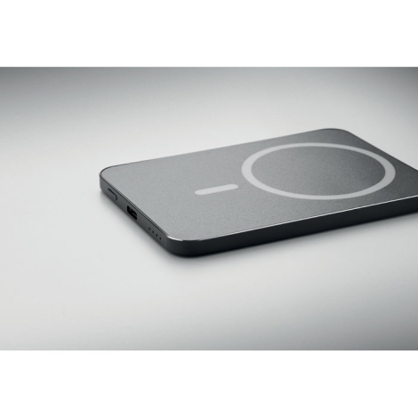 Vue en perspective du powerbank noir posé à plat, montrant son profil fin, son port USB-C et ses indicateurs latéraux.