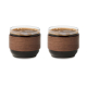 Deux tasses en verre remplies de café, avec leur large poignée en bois entourant la partie centrale. Deux tasses en verre remplies de café, avec leur large poignée en bois entourant la partie centrale.