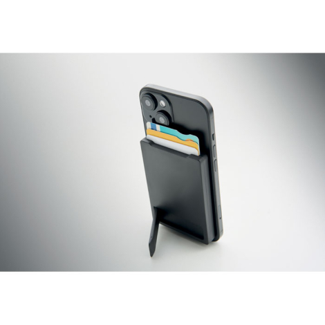 Smartphone posé à la verticale grâce au support déplié du porte-cartes magnétique fixé au dos, avec plusieurs cartes visibles da