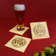 Trois sous-verres carrés en bois clair avec personnalisations imprimées, disposés sur fond rouge. Deux sont posés à plat et un t