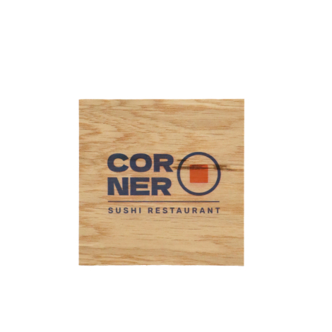 Sous-verre carré en bois brun clair, photographié à plat sur fond blanc, avec un veinage horizontal prononcé et une personnalisa