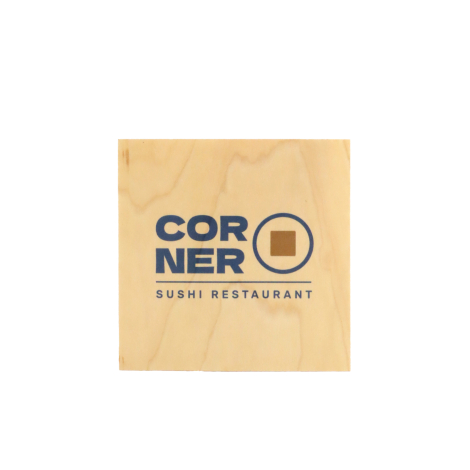 Sous-verre carré en bois blond, présenté à plat sur fond blanc, avec un veinage discret et une personnalisation centrale composé