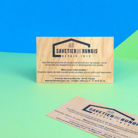 Deux cartes rectangulaires en bois clair avec personnalisation noire composée d'un logo et de textes, l'une présentée verticalem