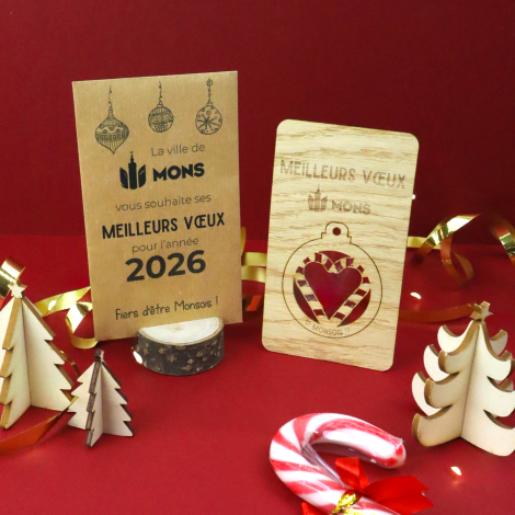 Carte de vœux en bois clair avec boule de Noël détachable ornée d'un flocon ajouré et d'un logo personnalisé. Présentée à côté d