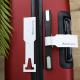 Deux étiquettes de bagage blanches en papier moucheté avec logo BlaBlaCar Daily, sur une valise rouge. L'une est fixée à la poig Deux étiquettes de bagage blanches en papier moucheté avec logo BlaBlaCar Daily, sur une valise rouge. L'une est fixée à la poig