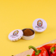 Boîtes rondes à épices personnalisées PILIPILI, contenant du paprika, présentées ouvertes et fermées sur fond jaune avec des poi