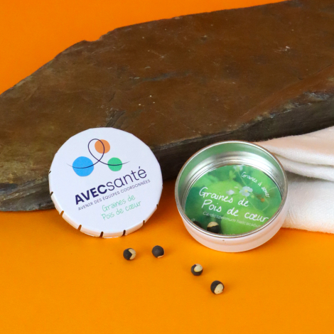 Boîte clic-clac blanche personnalisée AVECsanté, présentée ouverte avec des graines de pois de cœur et quelques graines dispersé