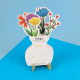 Calendrier de bureau personnalisable en forme de vase fleuri, avec fleurs multicolores en papier et logo Sintegra, présenté sur 