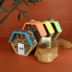 Hôtels à insectes personnalisables aux toits bleu, orange, jaune et vert, présentés sur des rondins de bois avec sachet de grain Hôtels à insectes personnalisables aux toits bleu, orange, jaune et vert, présentés sur des rondins de bois avec sachet de grain