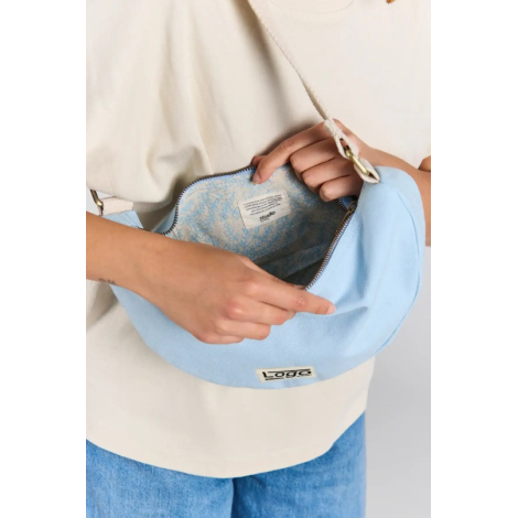 Gros plan sur l'intérieur du sac lune Inès bleu azur, ouvert par fermeture zippée, dévoilant une doublure à motifs floraux bleus