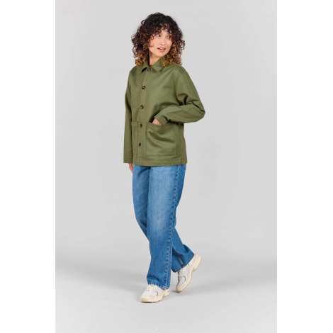 Femme portant la veste de travail Camille vert olive boutonnée, avec col chemise, manches longues et deux grandes poches plaquée
