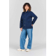 Femme portant la veste de travail Camille bleu marine, fermée par cinq boutons, avec col chemise, manches longues et deux grande Femme portant la veste de travail Camille bleu marine, fermée par cinq boutons, avec col chemise, manches longues et deux grande