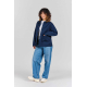 Femme portant la veste Camille bleu marine ouverte sur un t-shirt blanc, avec coupe droite, col chemise, manches longues et deux Femme portant la veste Camille bleu marine ouverte sur un t-shirt blanc, avec coupe droite, col chemise, manches longues et deux