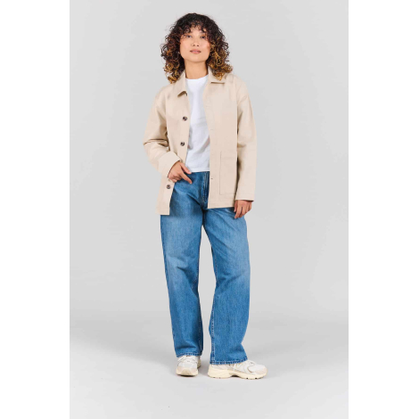 Femme portant la veste Camille écrue ouverte sur un t-shirt blanc, avec col chemise, manches longues, fermeture boutonnée et poc