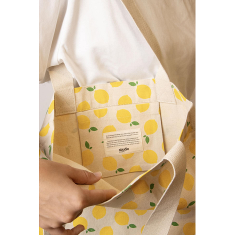 Vue détaillée de la poche intérieure du cabas Nina à motifs citrons jaunes, avec étiquette Studio by Hindbag présentant les enga