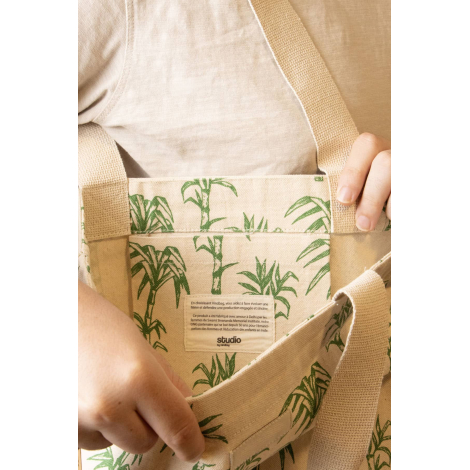 Vue détaillée de la poche intérieure du cabas Nina à motifs palmiers verts, avec étiquette Studio by Hindbag et anses écrues.