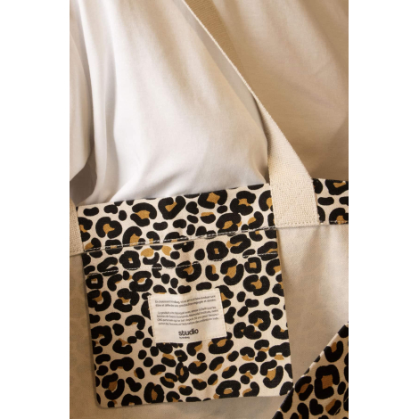 Vue détaillée de la poche intérieure du grand cabas Nina à imprimé léopard noir et fauve, avec étiquette Studio by Hindbag et an