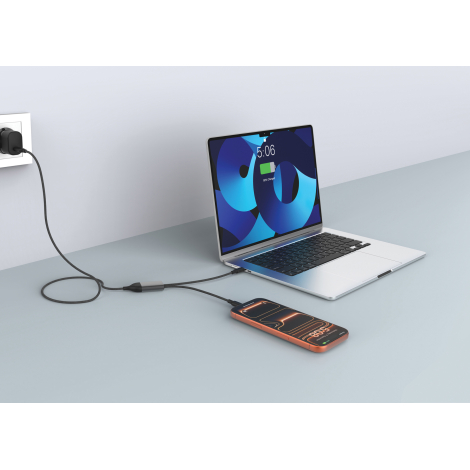 Mise en situation d'un câble de recharge gris foncé à gaine tressée, branché à un chargeur mural noir et alimentant simultanémen