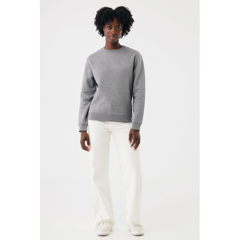 Femme debout de face portant un sweat gris chiné à col rond, manches longues et finitions côtelées. Elle l'associe à un pantalon