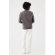Femme photographiée de dos, portant un sweat gris taupe à col rond et manches longues, associé à un pantalon blanc ample. Une co Femme photographiée de dos, portant un sweat gris taupe à col rond et manches longues, associé à un pantalon blanc ample. Une co