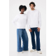 Une femme et un homme debout de face portent des sweats blancs unis à col rond et manches longues, associés à des jeans bleus am Une femme et un homme debout de face portent des sweats blancs unis à col rond et manches longues, associés à des jeans bleus am