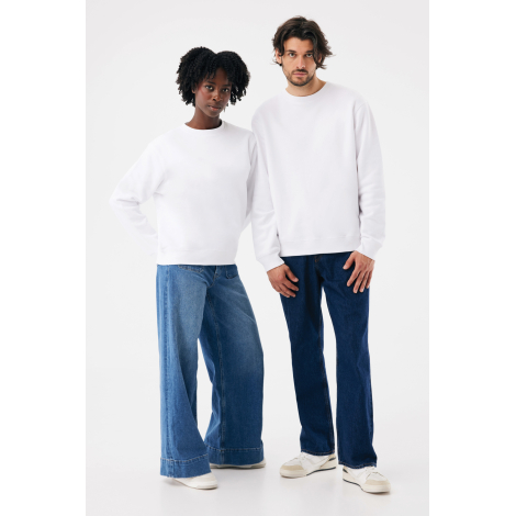 Une femme et un homme debout de face portent des sweats blancs unis à col rond et manches longues, associés à des jeans bleus am