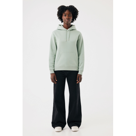 Femme portant un sweat à capuche vert sauge, présenté de face en pied. Coupe droite, manches longues, cordons de serrage assorti