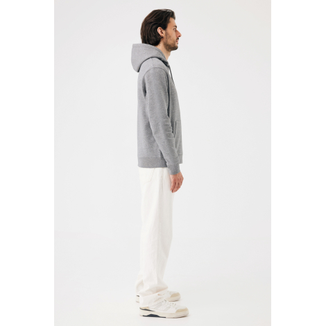 Homme portant un sweat à capuche gris chiné, présenté de profil en pied. La vue latérale montre la coupe droite, la capuche repo
