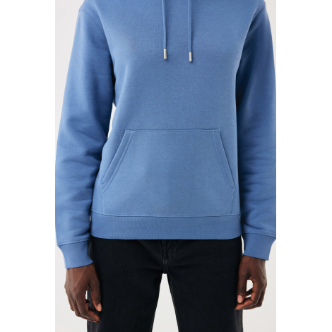 Gros plan sur un sweat à capuche bleu clair porté, cadré du buste aux hanches. Détail de la poche kangourou avec coutures appare