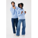 Homme et femme portant des sweats à capuche bleu pastel, présentés en pied. L'homme tient les bords de sa capuche relevée tandis Homme et femme portant des sweats à capuche bleu pastel, présentés en pied. L'homme tient les bords de sa capuche relevée tandis
