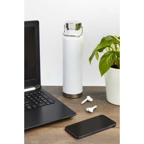 Bouteille réutilisable blanche en inox posée sur un bureau avec ordinateur et plante verte