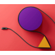Câble USB-C noir avec LED allumée, posé en diagonale sur fond rouge et violet