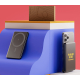 Power bank noir à personnaliser avec smartphone fixé magnétiquement, posé sur présentoir bicolore