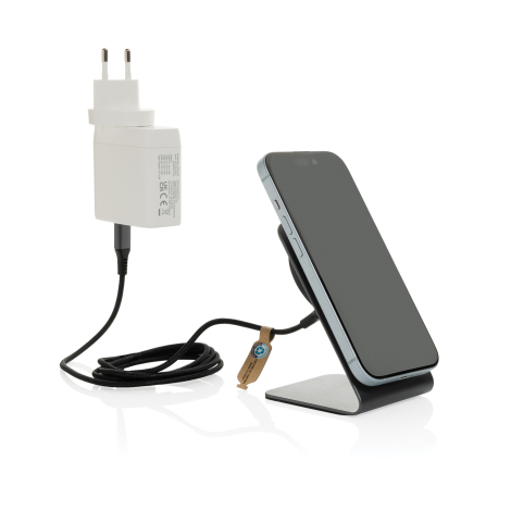 Support de charge gris branché au secteur rechargeant un smartphone posé