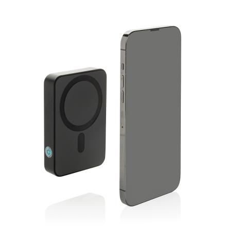 Batterie noire posée verticalement à côté d’un smartphone, vue de profil