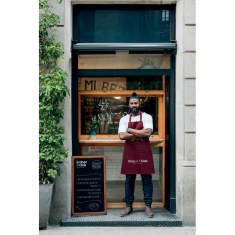 Tablier en coton bio porté devant un restaurant, marquage sur la partie basse.