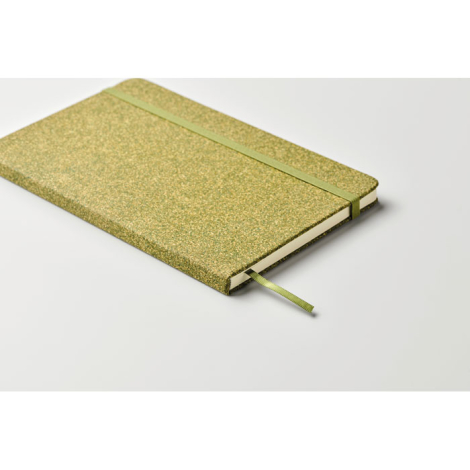Carnet A5 rigide vert posé à plat sur fond neutre, photographié de biais, sans marquage.