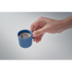Tasse à expresso en céramique bleue remplie de café, tenue à la main, sans marquage.