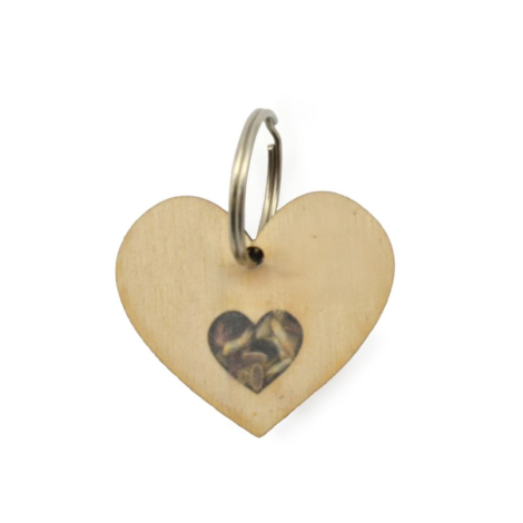 Porte-clés en bois en forme de cœur avec réservoir à graines, marquage visible.