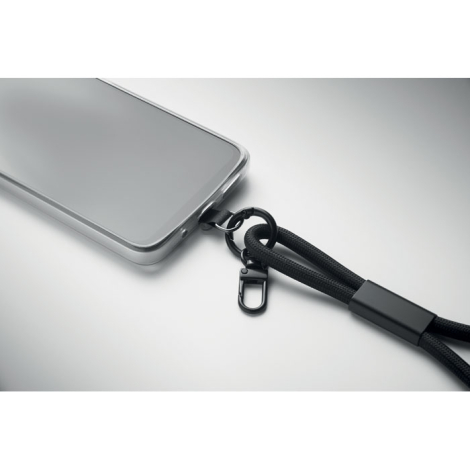 Gros plan sur la connexion du bracelet de chargement noir au smartphone gris.