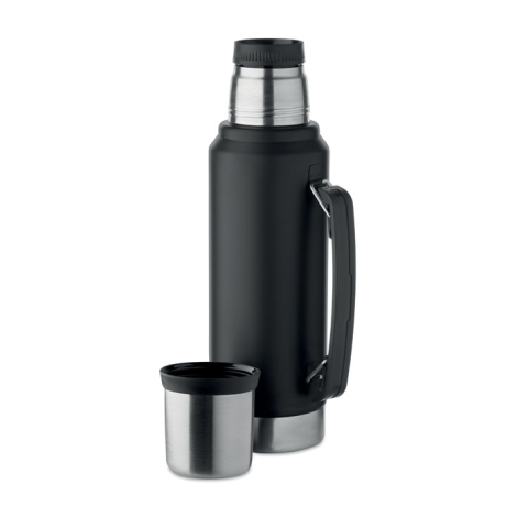 Bouteille isotherme noire avec poignée noire, bouchon inox et gobelet posé devant.
