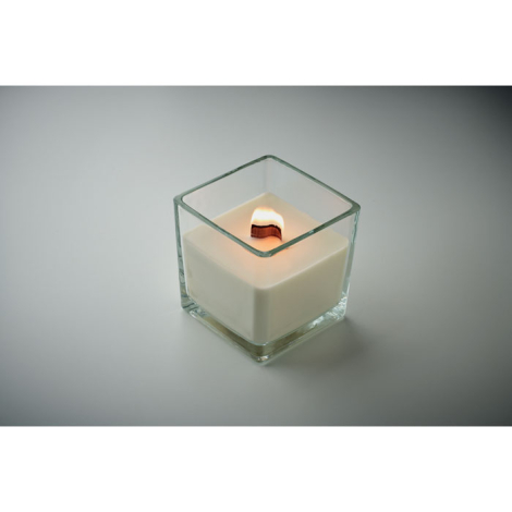 Bougie carrée allumée en verre transparent, vue en plongée.