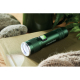 Lampe torche en aluminium vert foncé posée sur textile beige avec pierres et feuillage ; marquage visible sur la face latérale.