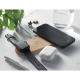 Station de charge en bambou sur table blanche rechargeant simultanément une montre connectée noire, un smartphone noir et des éc