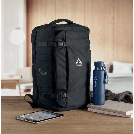 Sac de voyage noir posé sur une table en bois, avec marquage visible sur la face avant et la poche latérale gauche.