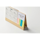 Calendrier de bureau en carton recyclé vu de dos avec pages reliées en spirale, sans personnalisation visible.